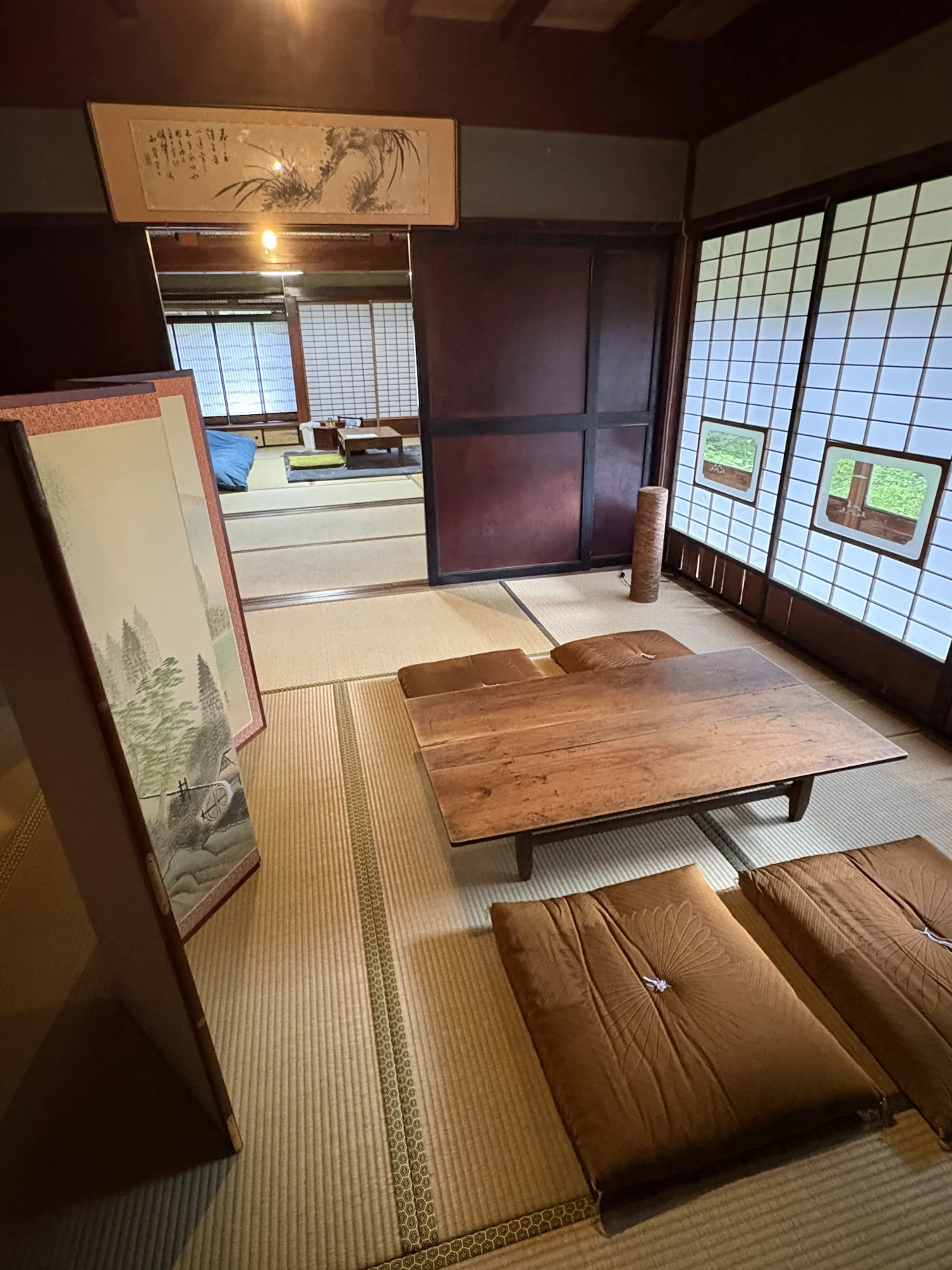 木のテーブルと座布団が並ぶ和室ラウンジ